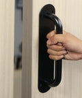 11 Inch Stainless Steel Gate Handle With Matte Black Finish, Easy Push Pull Plate on wood door, user gripping the handle LS8280-B