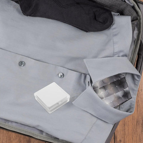 Slick Invisible Collar Stays For Men Dress Shirts in a suitcase next to a gray shirt and socks, compact PVC design.