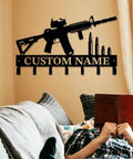 Custom Name Gun Themed Wall Hooks For Keys And Coats mounted above a person reading on a sofa, metal design.