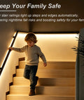 Ultra Smooth Body Sensing Lighted Stair Handrail For Indoor Steps Wall Mounted Safety Rail With Sleek Black Powder Coat guiding a child down stairs.
