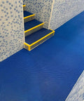 Grab This Killer Non Slip Outdoor Drainage Mat Measuring Three Feet By Ten Feet Perfect For Commercial Kitchen Floors Garage Poolside Bathroom And Restaurant Use With Awesome S Shaped Design That Drains Water Fast And Stays Super Clean shown in a blue flooring with tiled steps.