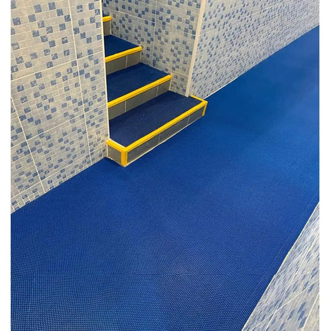 Grab This Killer Non Slip Outdoor Drainage Mat Measuring Three Feet By Ten Feet Perfect For Commercial Kitchen Floors Garage Poolside Bathroom And Restaurant Use With Awesome S Shaped Design That Drains Water Fast And Stays Super Clean shown in a blue flooring with tiled steps.