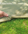 Hand holding edge of Ultralight Waterproof Tent Footprint Ground Sheet For Camping on grass showing waterproof PU coating.