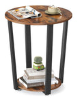 Round Side End Table Featuring Two Tier Storage Shelf No Sweat Assembly Nightstand For Cramped Rooms Super Sleek Bedside Accent Table In Rustic Brown And Ink Black For Living Space Or Bedroom Decor Total Haul with magazines and a cup on top.