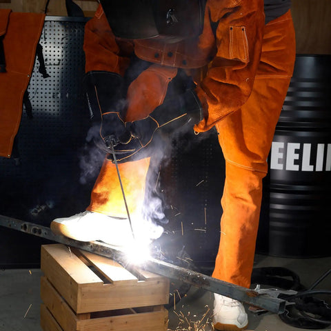 Split Leather Welding Pants With Heat And Flame Resistant Safety Leg Protection For Men And Women, Adjustable From M To XXXL, Regular 34 Inch, Durable Brown Workwear in action during welding.
