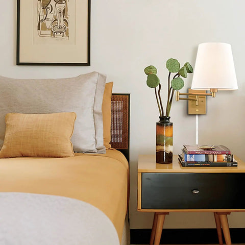 Gold Swing Arm Wall Sconces Two Pack Plug In Brass Wall Lights With White Fabric Shade in bedroom with nightstand