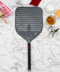Perforated 12 Inch Pizza Peel, Metal Pizza Turner For All Ovens, Indoor Outdoor Use, Lightweight And Durable Anodized Aluminum With Heat Resistant Handle on marble counter