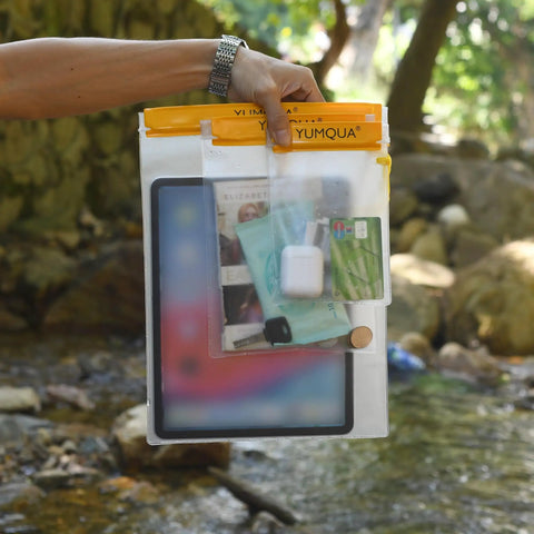 Clear Waterproof Dry Bags Set Of Three Pouches For Phone, Camera, Maps And Documents, frosted PVC case outdoors near stream.