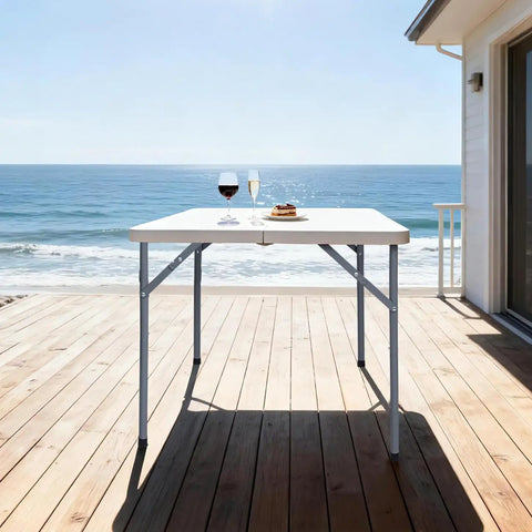 34-Inch Square Folding Table With Carrying Handle on beachside deck, fold-in-half design, heavy duty HDPE construction, supports 330 lbs