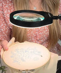 Person using 10X Magnifying Desk Lamp With 96 LEDs, 5 Inch Real Glass Lens for detailed embroidery work