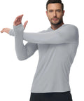 Model wearing Men's Hooded Rash Guard Long Sleeve UPF 50 Plus Sun Protection For Fishing And Beach Wear Quick Dry Breathable 4 Way Stretch Raglan Thumb Hole Shirt Gray XL, showing flexibility of the fabric.