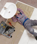 Worker under sink on Quick Drop 8 Oz Canvas Safety Drop Cloth With Slip Resistant Dots, Heavy Duty Floor Protector 3.5x4 Feet