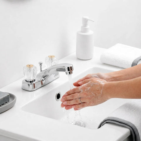 Upgrade Your Bath With This 2 Pack Clear Acrylic Faucet Knob Replacement Kit That Slaps Perfectly On Delta Delex Peerless And Ldr Two Handle Tub Or Sink Fixtures Featuring Screws And A Pry Tool For Easy Swapping. Clear acrylic two-handle faucet knobs on a white bathroom sink, hands washing