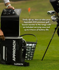Man setting up Approach R50 Golf Launch Monitor And Simulator Bundle with case and golf clubs on the grass