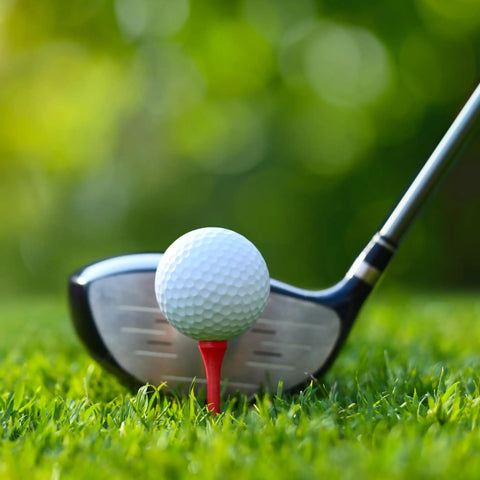 A golf ball on a Two And Three Quarter Inch Red Wood Golf Tees Pack Of 100 Built For Real Players With Pro Grade Performance on grass