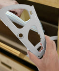 Stainless steel shoe cabinet hinge plate held by hand, front view with mounting holes