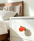 Adorable 3D Peach Cabinet Knobs And Drawer Pulls For A Fresh Playful Home Vibe on a white dresser beside a cozy bed.