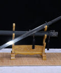 Beefy Damascus Tang Dao Sword With Black Gold Finish displayed on a stand, featuring a full tang and traditional folding pattern.