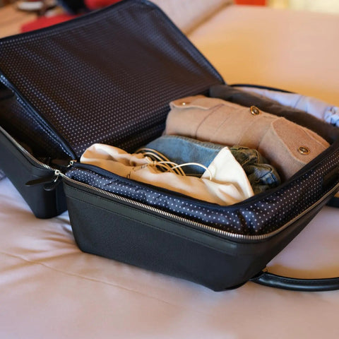 Carry On Ready Duffle Travel Bag With Clamshell Opening, 33 Liter Capacity, showcasing open bag with clothes inside on a bed.