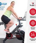 Person using bike with Dual Function Toe Cages For Peloton Pedals So You Can Roll In Sneakers Or Peloton Shoes And Switch Shoes