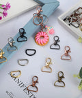 100 Piece Hardcore Swivel Keychain Clips With D Rings And Lobster Clasps 24mm Snap Hooks in various colors arranged on a flat surface.