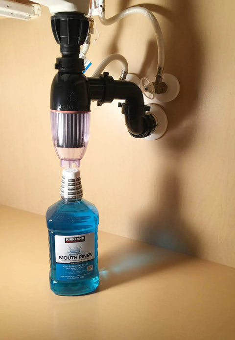 Under-sink view of No Mess Money Saving P Trap 2 Pack In Black And Transparent Easy To Install Under Sink Plumbing Upgrade with mouth rinse