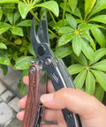 7 In 1 Garden Pruning Shears Folding Multitool With 8 Inch Professional Garden Scissors held in hand cutting plant