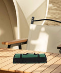 Large Capacity Knife Roll Bag For Chefs with tear-resistant fabric on wooden table, portable handle visible for outdoor use.