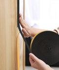 Tough As Nails Weather Stripping Door Seal Strip applied on wood, 32.6 ft roll, helping to block chills and dust in classic black.