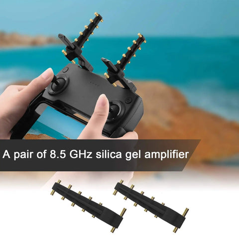 Hands holding a drone remote with attached 8.5GHz Yagi antennas for signal boosting, landscape in the background.