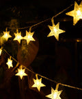 Warm White 50 LED Five Point Star Fairy Lights glowing indoors, battery-powered, highlighting 1.6 inch star beads