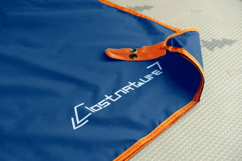 Close-up of blue ripstop Tent Footprint Ground Cloth Waterproof Tarp For Camping And Backpacking, orange edge and grommet visible.