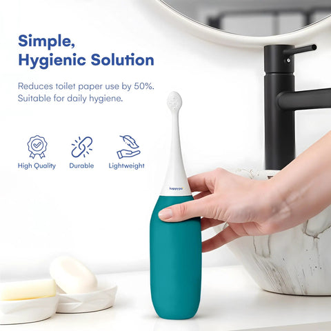 Hand holding XL Butt Shower Portable Bidet With 50 Percent More Water Volume in turquoise, next to sink