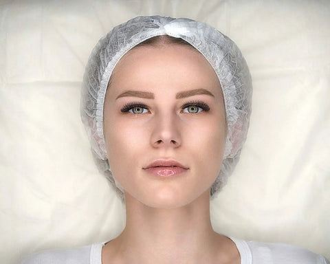 Woman wearing Disposable Bouffant Hair Caps 21 Inch Head Cover Net For Salon Or Spray Tan Breathable Nonwoven Fabric With Elastic Band