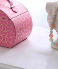 Eight Point Eight Inch Hot Pink Travel Jewelry Organizer Case With Built In Mirror And Snug Pockets To Keep Your Bling Safe During Any Weekend Dash Or Cross Country Drive displayed next to a decorative bust with colorful beads.
