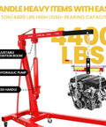 Heavy Duty 2 Ton Engine Hoist With Retractable Telescopic Boom And Six Rolling Caster Wheels Portable Hydraulic Cherry Picker lifting an engine.