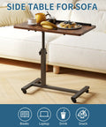 Adjustable Overbed Table With C Shape Design Portable Rolling Desk beside sofa with snacks and books, wood-textured top.