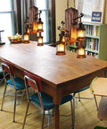 Industrial Vintage Wooden Hanging Pendant Light With Four Lantern Bulbs above a wooden dining table, rustic setting