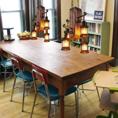 Industrial Vintage Wooden Hanging Pendant Light With Four Lantern Bulbs above a wooden dining table, rustic setting