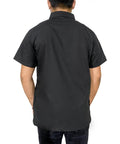 Back view of a man wearing a Slick Half Sleeve Barber Jacket Zip Front Men Salon Smock Lightweight Black Hairdresser Uniform.