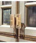 4 Pieces 3.93 Inch Gold Zinc Alloy Cabinet Handles With Hollow Geometric Design on a wooden cabinet