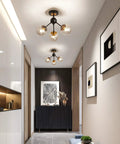 3 Light Vintage Semi Flush Mount Glass Globe Chandelier In Black Finish in a modern hallway setting.