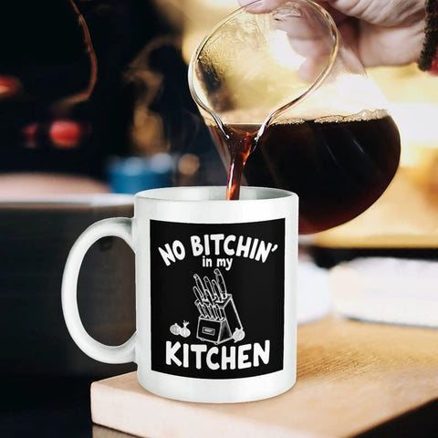 No Bitchin' In My Kitchen 11 Oz Ceramic White Mug With Comfortable Handle, coffee being poured, home or kitchen setting.