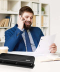 Businessman using Low-Force No-Fuss 3-Hole Punch for 20-Sheet Capacity, heavy-duty desktop paper punch with squeeze handle, in office setting