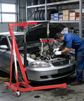 Mechanic using Heavy Duty Hydraulic Engine Hoist With Lever 1.5 Ton Capacity 3000 Lbs Shop Crane in garage