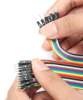 Hands holding color-coded MF MM FF jumper wires from Three Pack Jumper Wires And Three Solderless Breadboard Sets With 830 Tie Point Breadboards