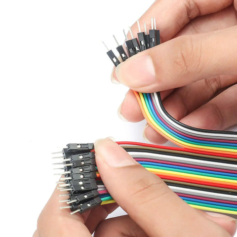 Hands holding color-coded MF MM FF jumper wires from Three Pack Jumper Wires And Three Solderless Breadboard Sets With 830 Tie Point Breadboards