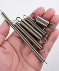 Must Have Stainless Steel Tension Springs With Hooks, various sizes, durable metal, shown in hand for auto or industrial projects.