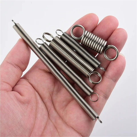 Must Have Stainless Steel Tension Springs With Hooks, various sizes, durable metal, shown in hand for auto or industrial projects.