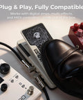 Close-up of dual expression pedal in use with amps and MIDI controllers, featuring two outputs and polarity switches on pedalboard setup.